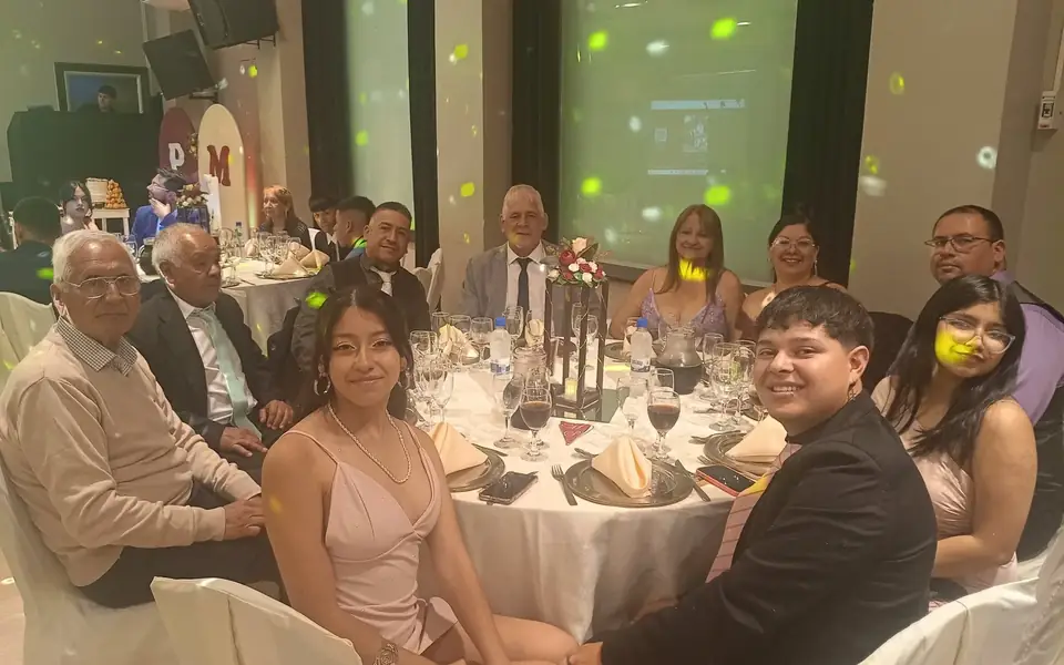 Invitados sentados alrededor de la mesa durante la fiesta