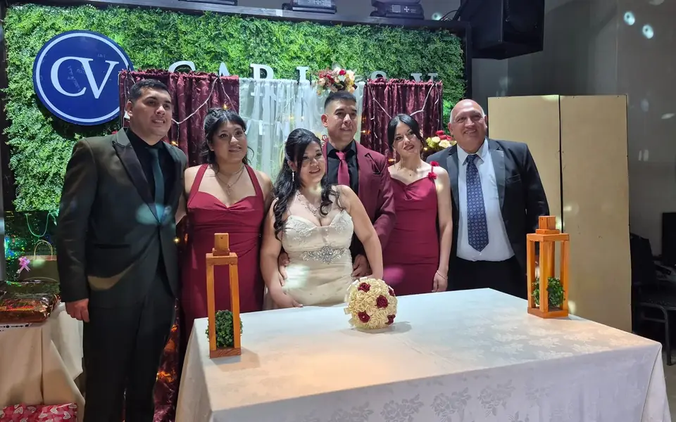 Los novios posan con su familia junto a la mesa de la ceremonia